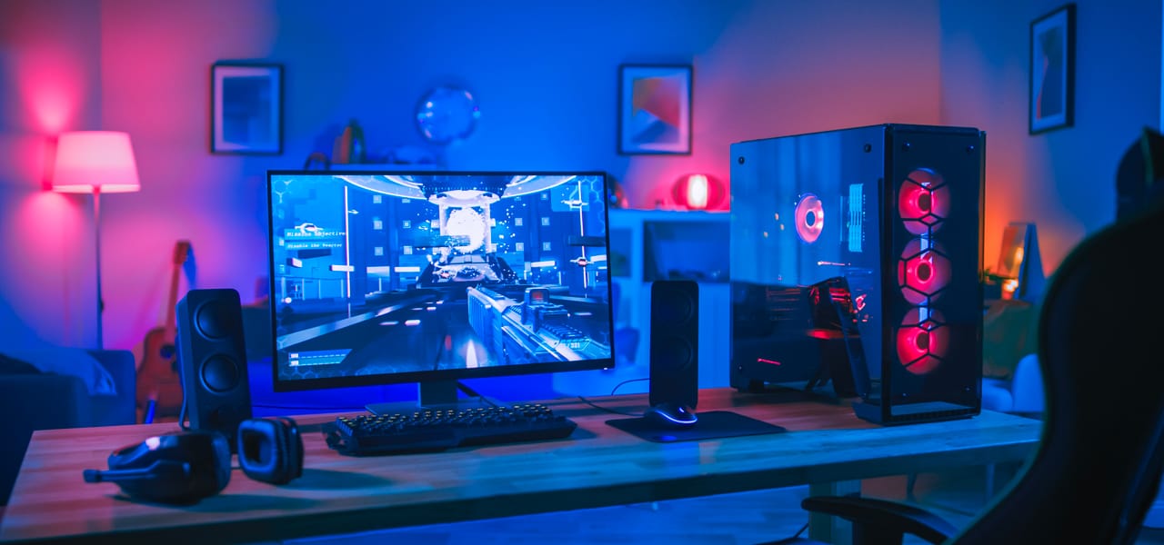 Ordinateur gaming dans une chambre avec un éclairage tamisé et du RGB.